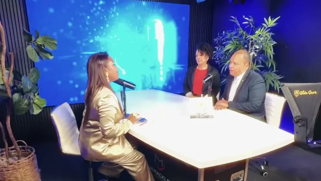 Mesa de entrevista en el estudio con tres personas y una pantalla LED detrás