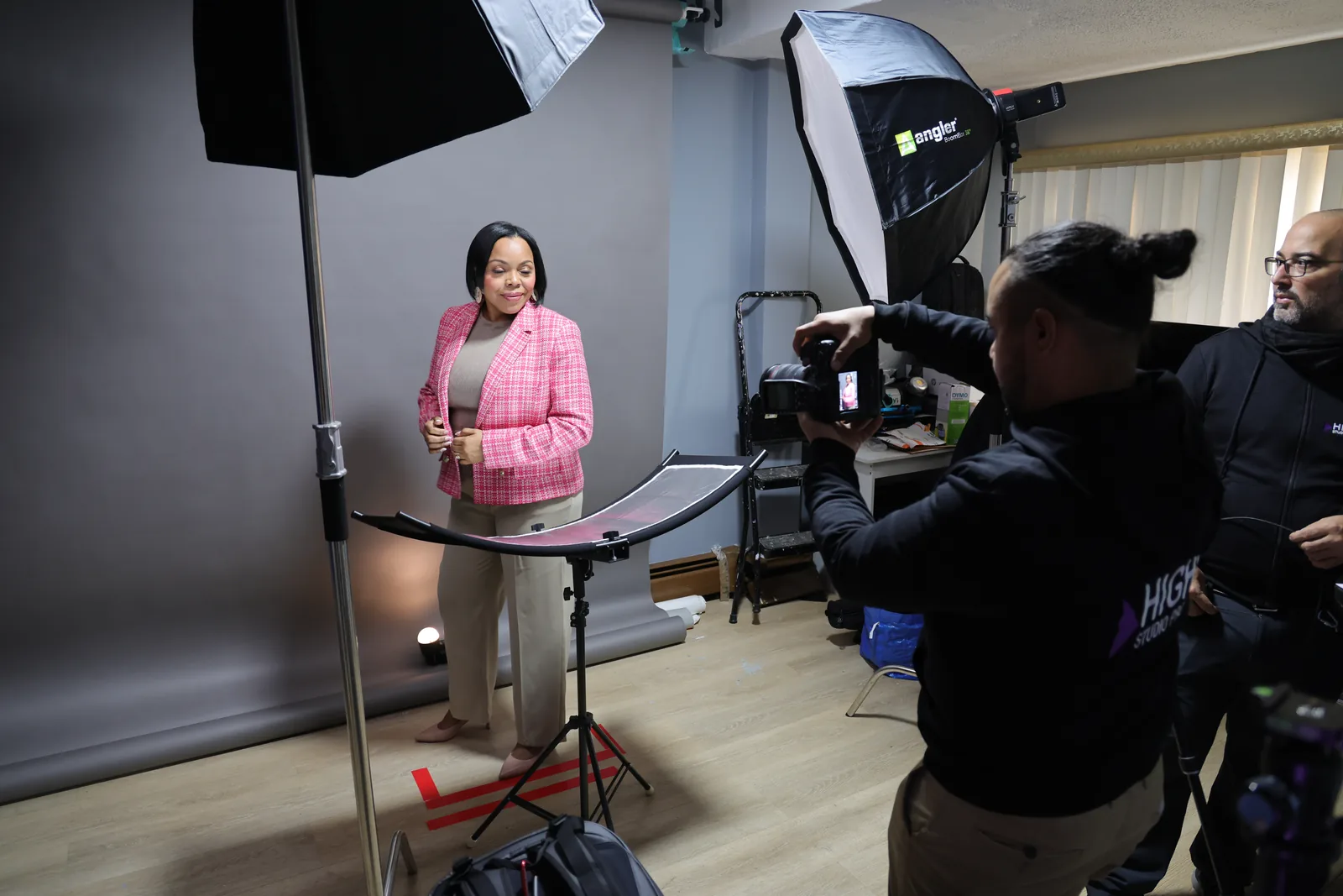 Sesión de retrato corporativo: dos softboxes, un reflector y una marca en el suelo.